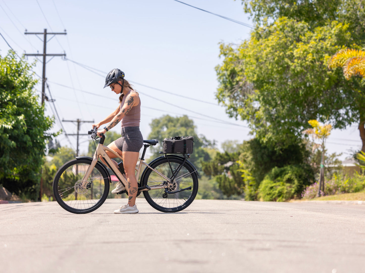 Rider commuting on a Troxus Trax Sport electric bike featuring integrated battery and rear cargo rack