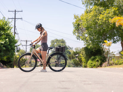 Rider commuting on a Troxus Trax Sport electric bike featuring integrated battery and rear cargo rack